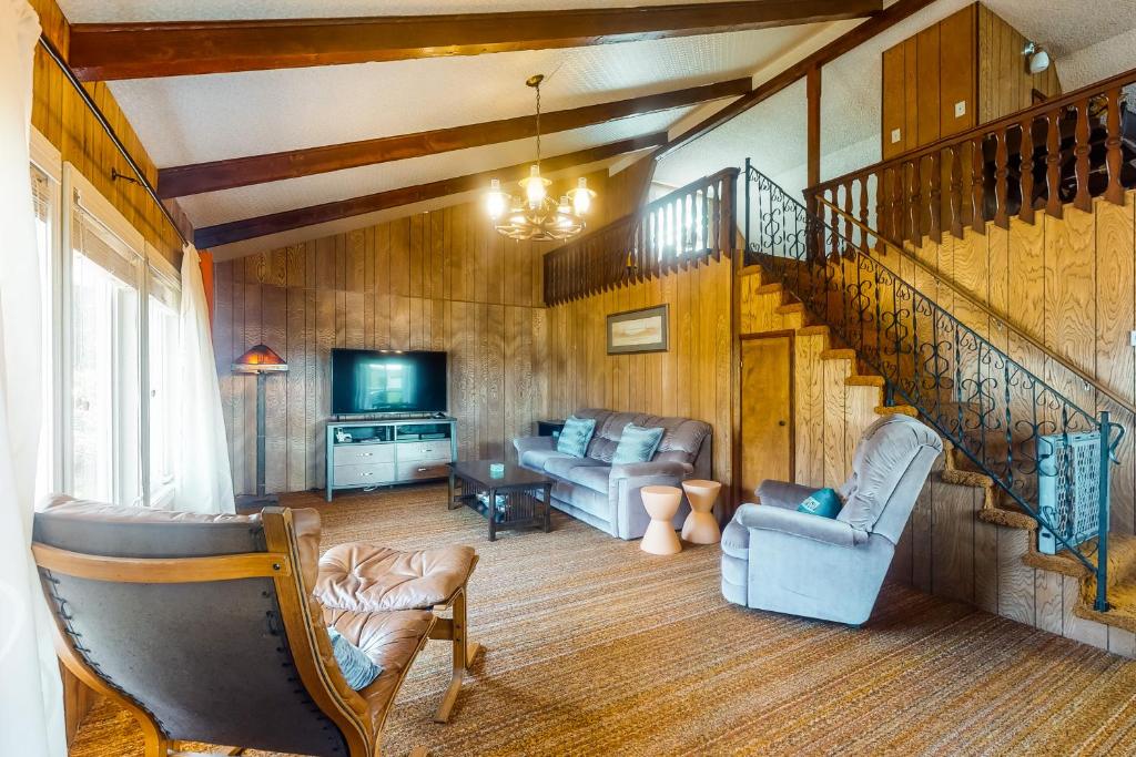 a living room with a staircase and a couch at That '70s House in Rockaway Beach