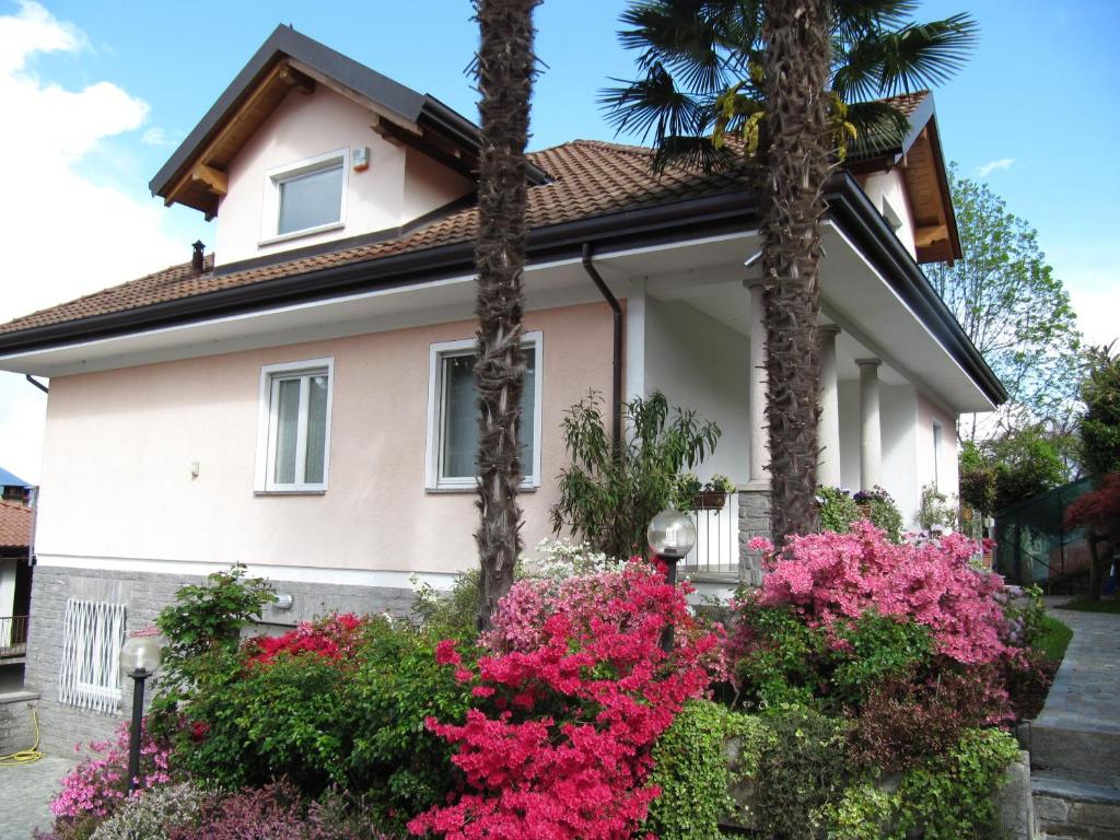 ein Haus mit rosa Blumen und Palmen in der Unterkunft Ori Villa Oriana in Baveno