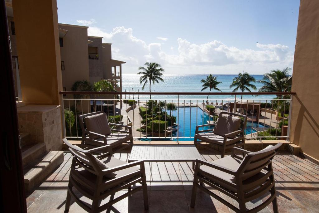 Un balcón con sillas y vistas al océano. en El Faro 304 Coral Penthouse, en Playa del Carmen