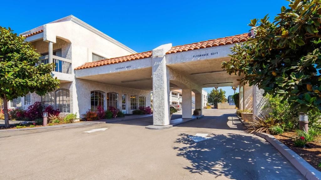 a large white building with a covered parking lot at SureStay Hotel by Best Western Camarillo in Camarillo