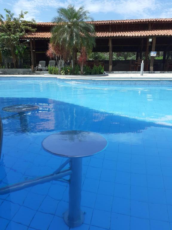 uma mesa no meio de uma piscina em Chalé em Barreirinhas - Porto dos Lençóis em Barreirinhas