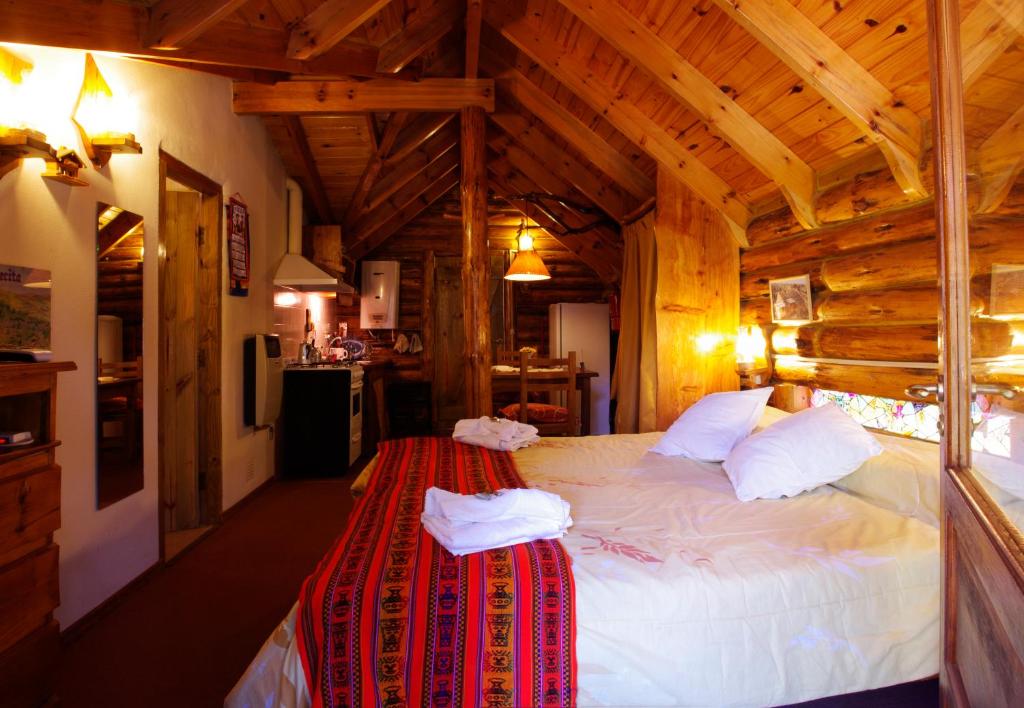 ein Schlafzimmer mit einem großen Bett in einem Holzzimmer in der Unterkunft Cabañas Am Hang in La Cumbrecita