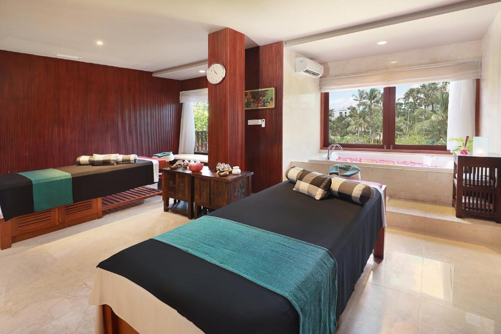 Postel nebo postele na pokoji v ubytování Legian Beach Hotel