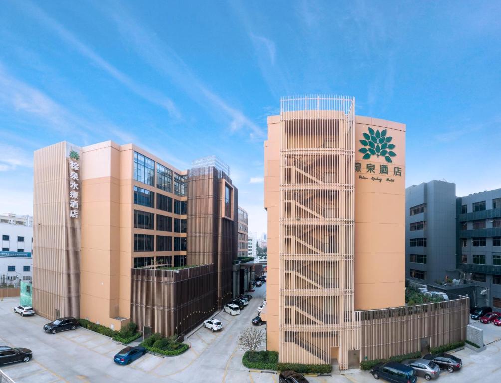 un grand bâtiment avec un panneau pentagone à côté de deux bâtiments dans l'établissement Zhuhai Palm Spring Hotel, à Zhuhai