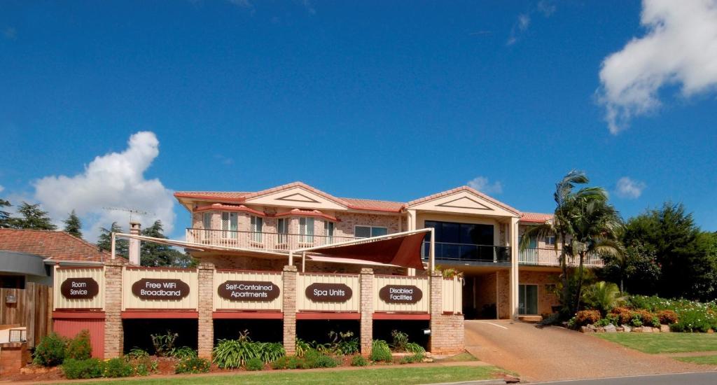 a house with a sign in front of it at Highlander Motor Inn in Toowoomba