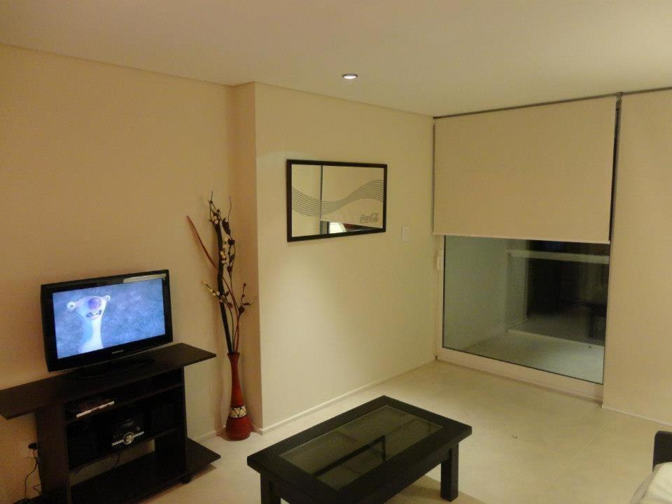 a living room with a television and a table at Marco Polo Natura Apartamento in Mar del Plata