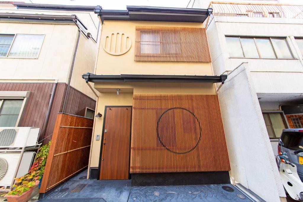 a house with a gate with a circle on it at Kyoto Backyard Fox in Kyoto