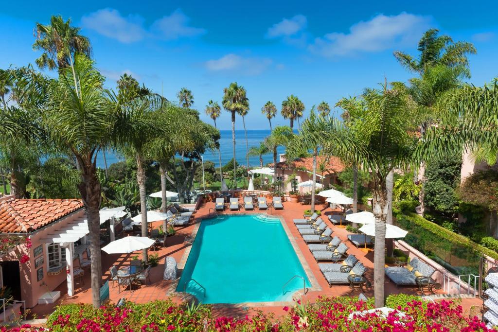 an aerial view of a resort pool with chairs and umbrellas at La Valencia Hotel in San Diego