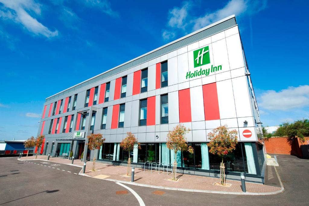 a building with a pharmacy sign on the side of it at Holiday Inn London Luton Airport, an IHG Hotel in Luton