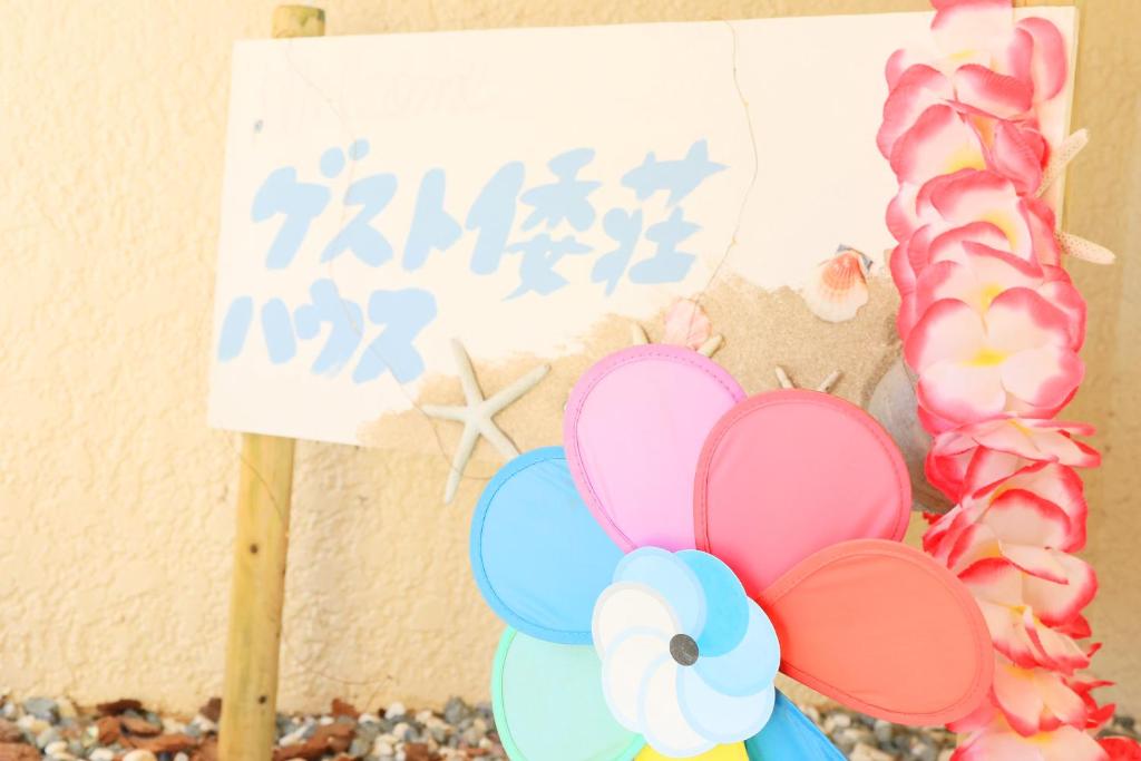 a sign next to a bunch of donuts and a sign with balloons at Guest House YAMATOSO in Ito