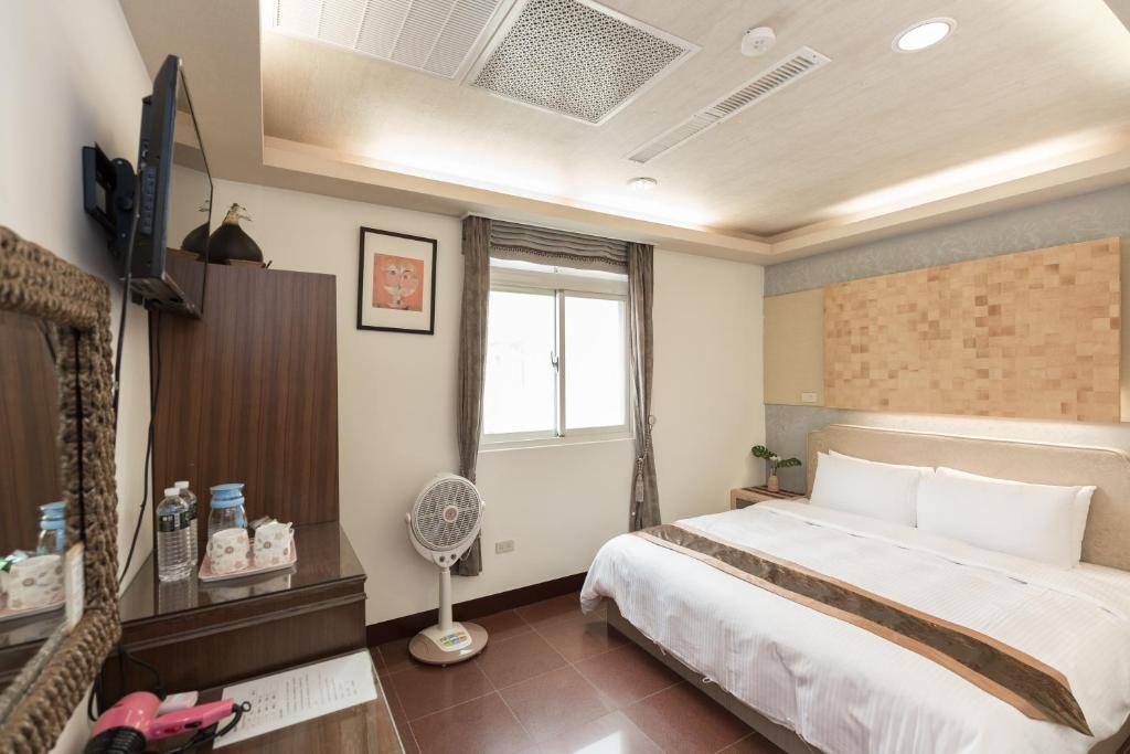 a hotel room with a bed and a television at Be my house in Magong
