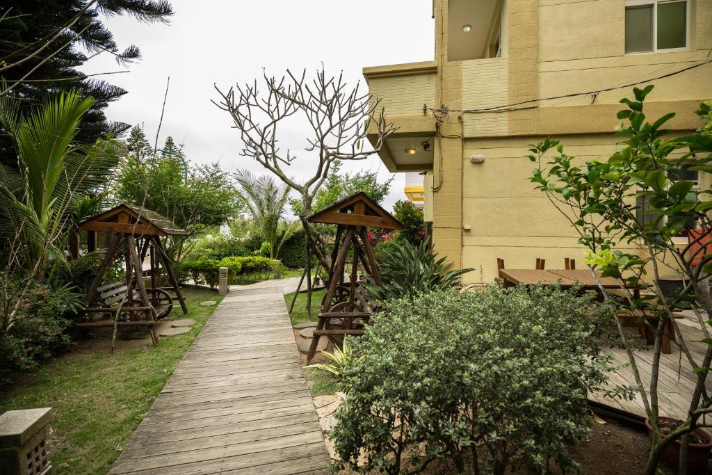 a wooden walkway next to a building with a house at Be my house in Magong