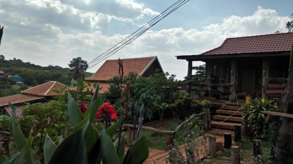 une maison avec une clôture devant elle dans l'établissement Ratanak Tep Rithea homestay, à Banlung
