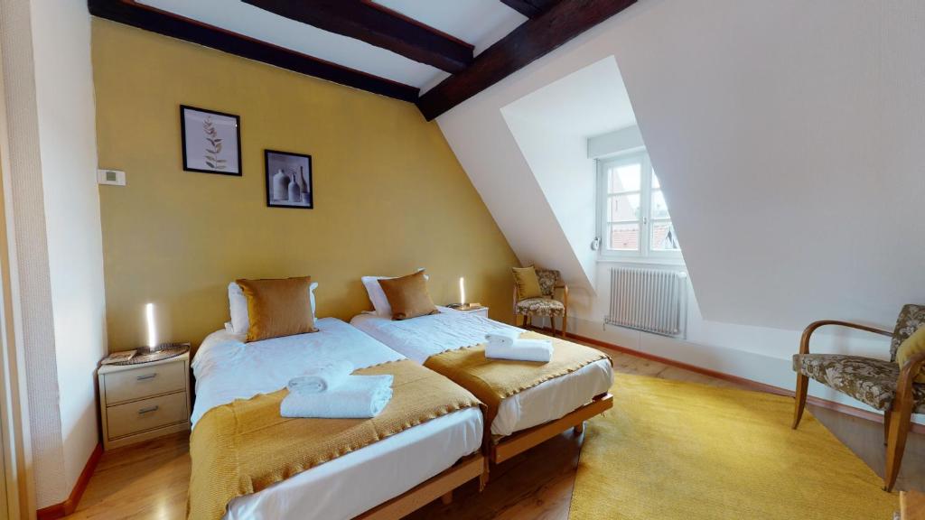 um quarto com uma cama e uma grande janela em Aux Bijoux de Colmar - Le Saphir - 1 PARKING GRATUIT em Colmar