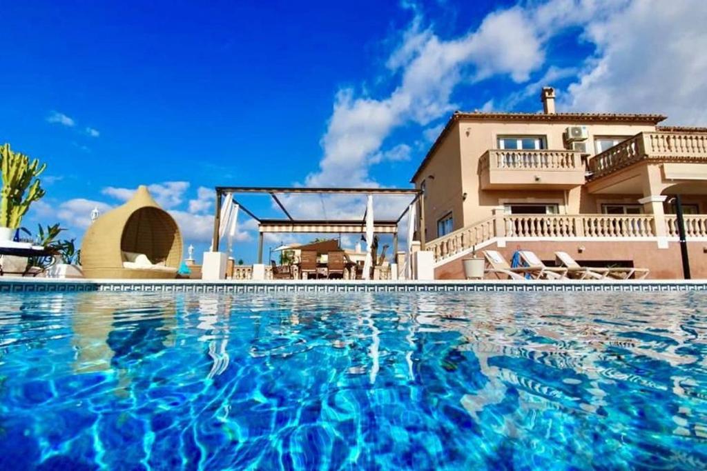 a large swimming pool in front of a house at Villa Versace súper lujo 14 huéspedes + invitados in Palma de Mallorca