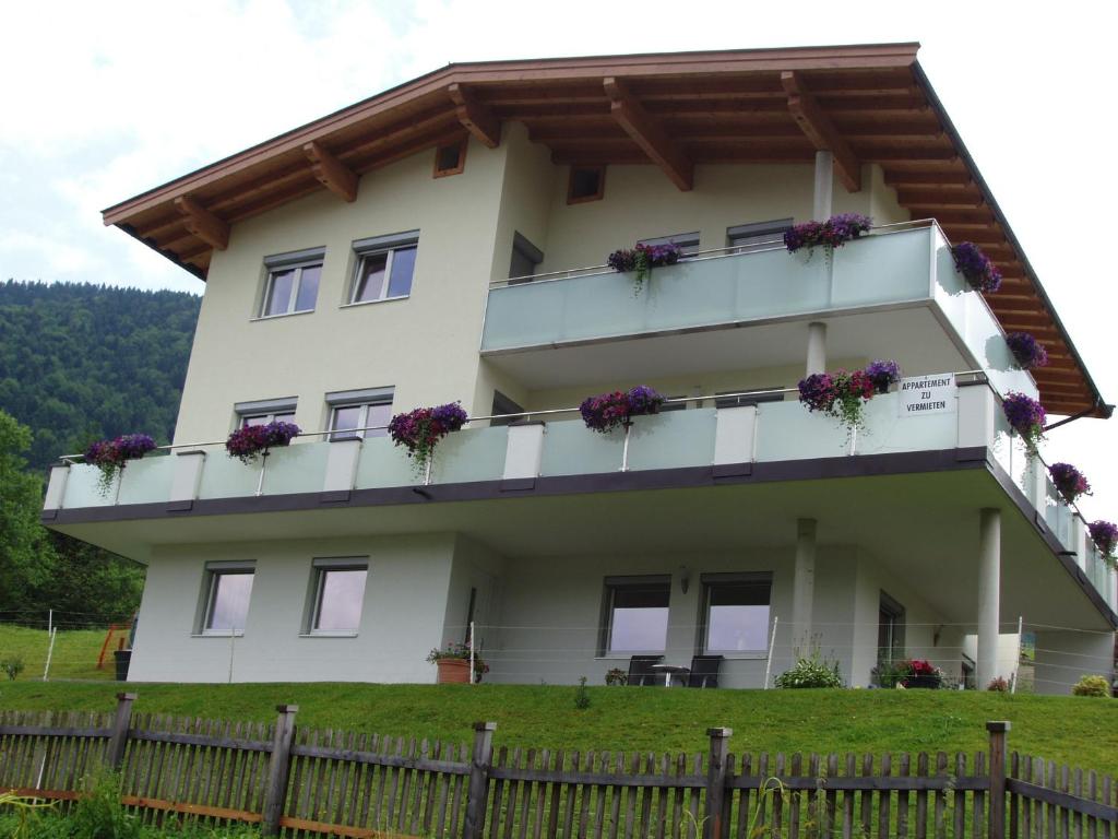 a house with flowers on the balconies of it at Appartement Wohlfartstätter in Walchsee
