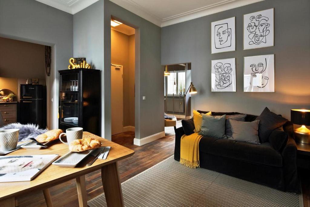 ein Wohnzimmer mit einem Sofa und einem Tisch in der Unterkunft Chase Apartments-Boutiquehotel Style I in Würzburg