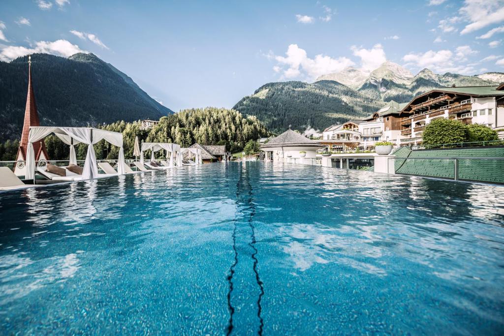 una gran piscina de agua con montañas en el fondo en Stock Resort en Finkenberg