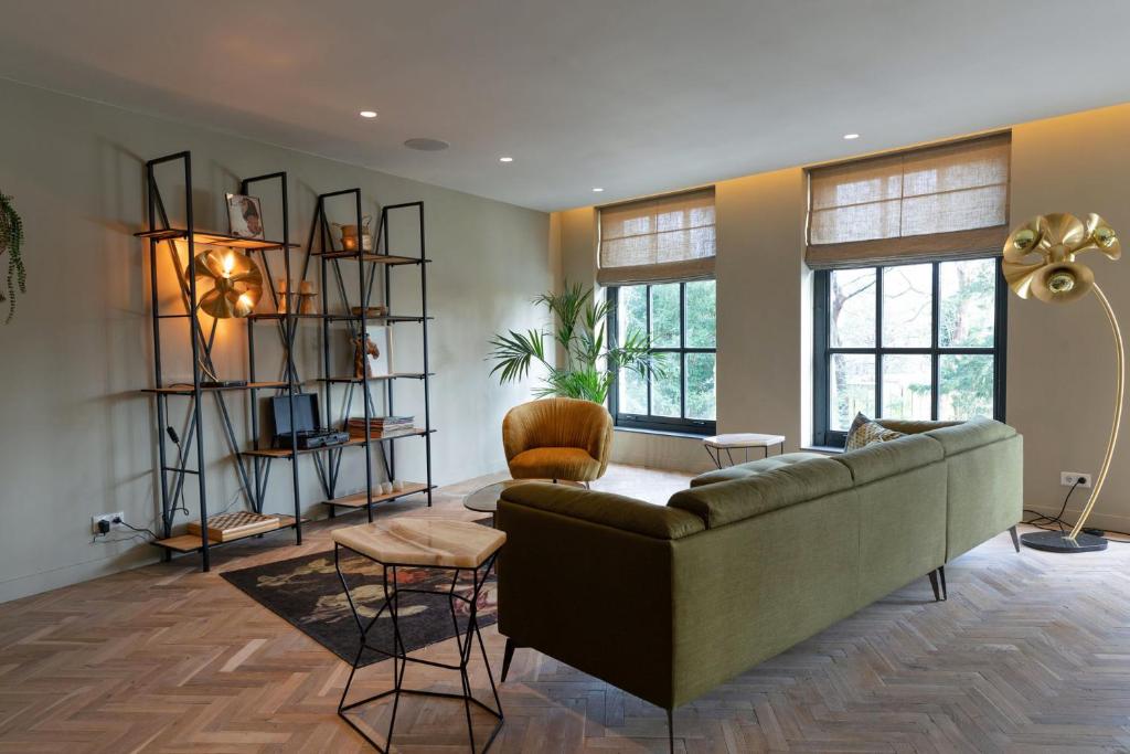 uma sala de estar com um sofá e algumas janelas em Parkhotel Abcoude em Abcoude