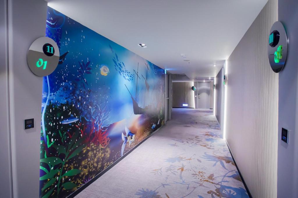 a hallway with a wall mural of an aquarium at The Cloud Hotel in Taichung