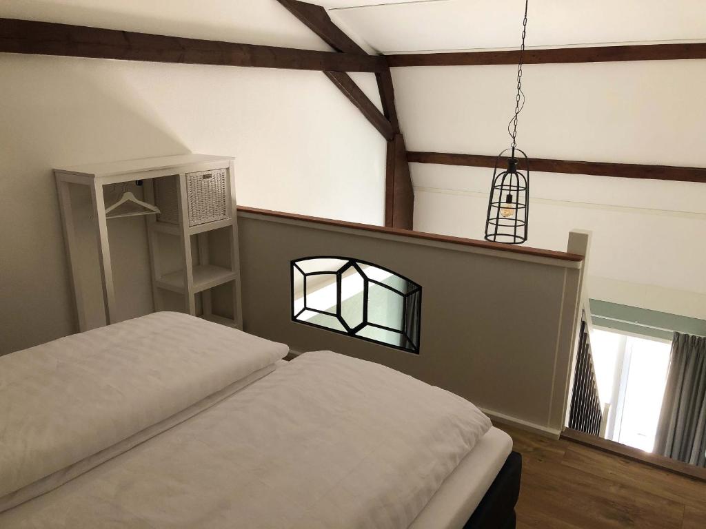 a bedroom with a bed and a chandelier at B&B De Hoffstal in Sassenheim