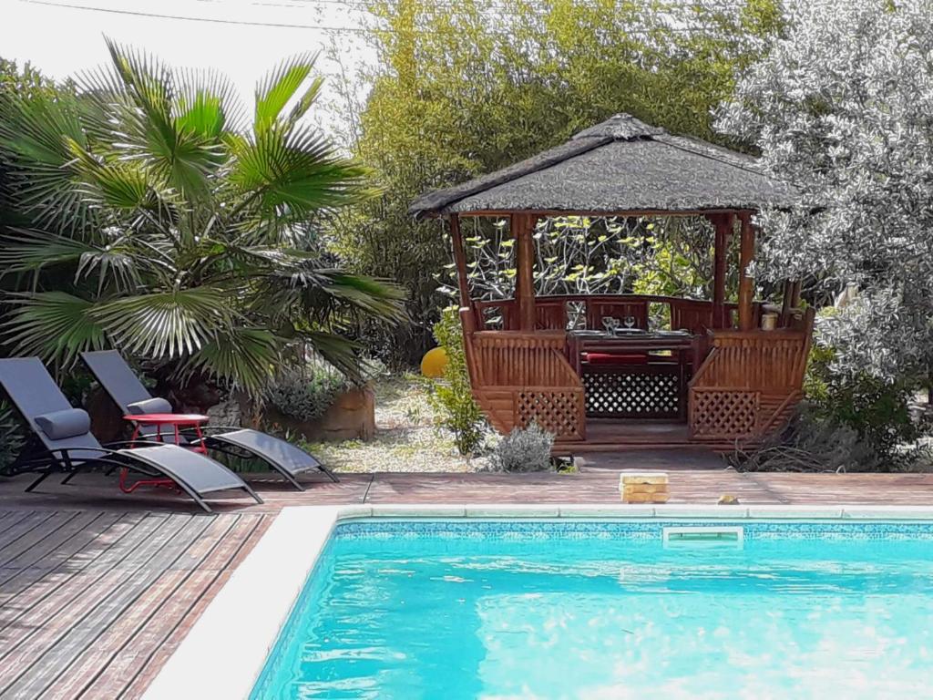 uma piscina com um gazebo, uma mesa e cadeiras em Villa Madura em Canet