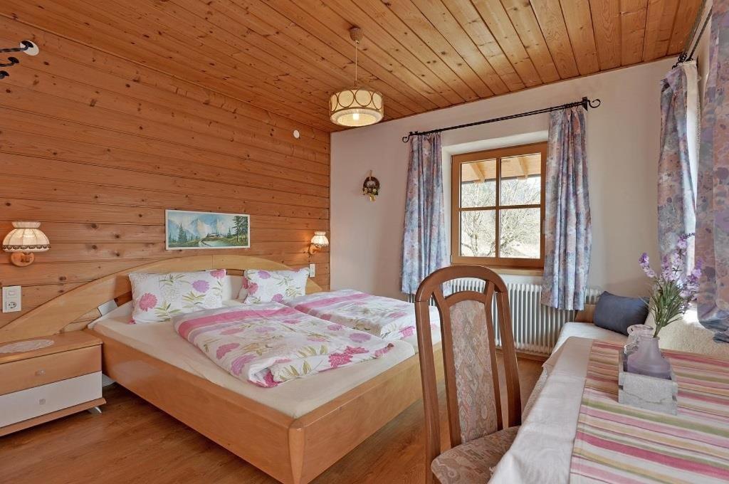 - une chambre avec un lit dans une pièce en bois dans l'établissement Biobauernhof und Ferienhaus Riederbauer, à Rettenschöss