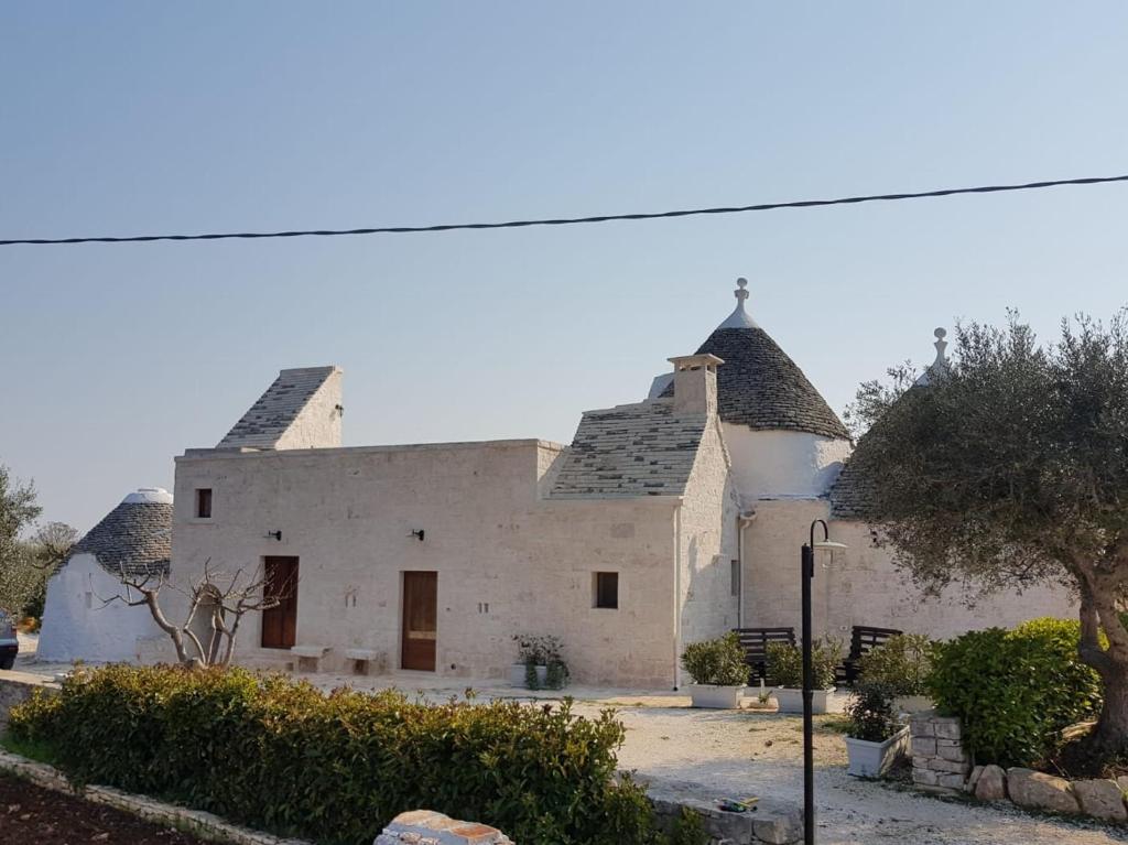 een groot wit gebouw met een dak bij Trulli stett in Cisternino