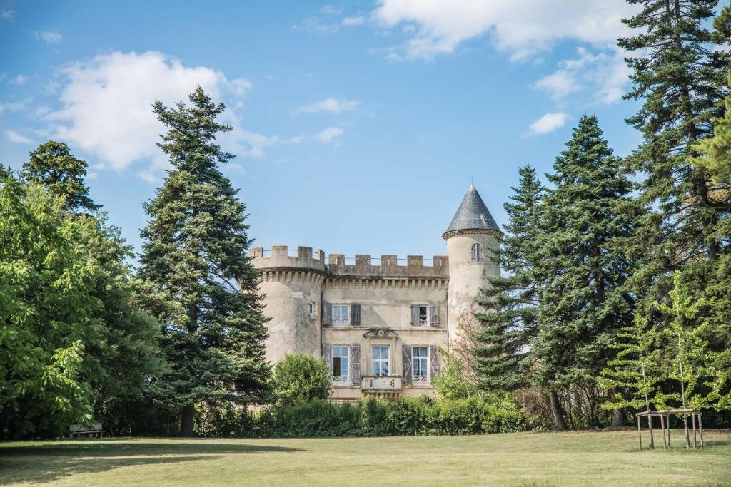 un viejo castillo con árboles delante de él en Château Emile Loubet - appartement Maréchal Lyautey en La Bégude-de-Mazenc