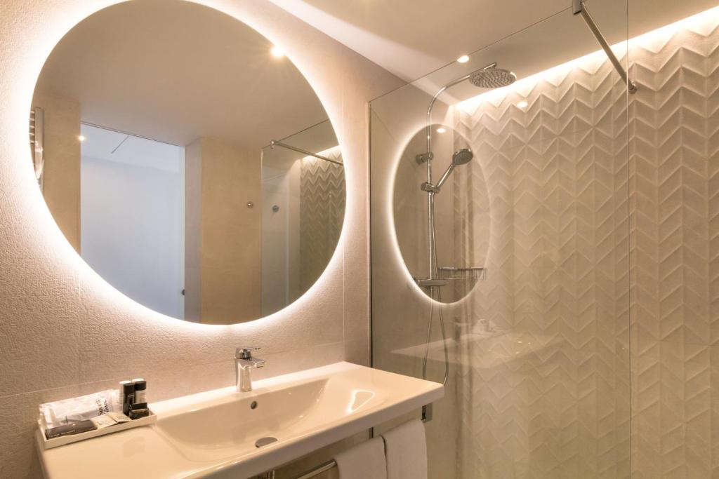 un baño con lavabo y espejo en Hotel Cap Negret, en Altea