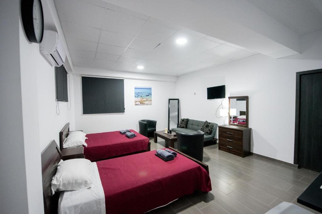 Una habitación de hotel con dos camas y un televisor. en Central Luxury Studios, en Ayia Napa