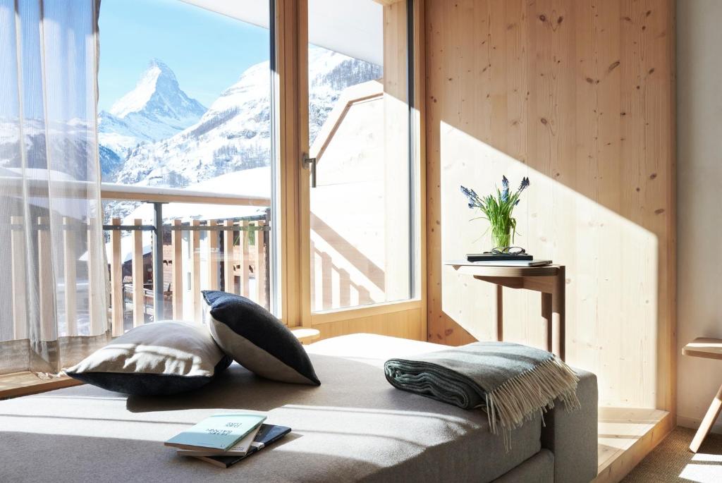 a bedroom with a bed with a view of a mountain at Carina - Design&Lifestyle hotel in Zermatt