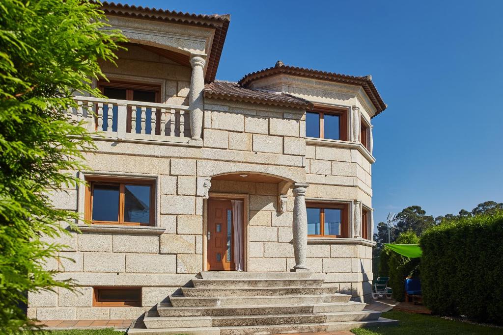 une maison en pierre avec des escaliers en face de celle-ci dans l'établissement Gándara Chalet, à Salvatierra de Miño