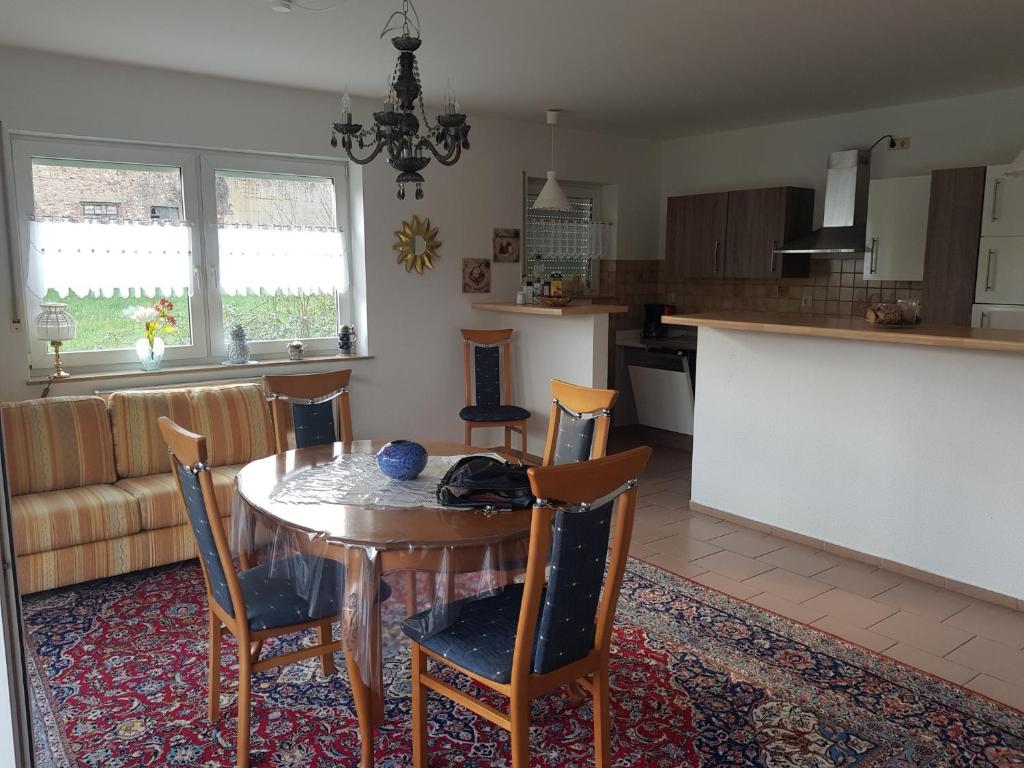 a kitchen and dining room with a table and chairs at Nicoles Niedschlösschen in Rehlingen-Siersburg