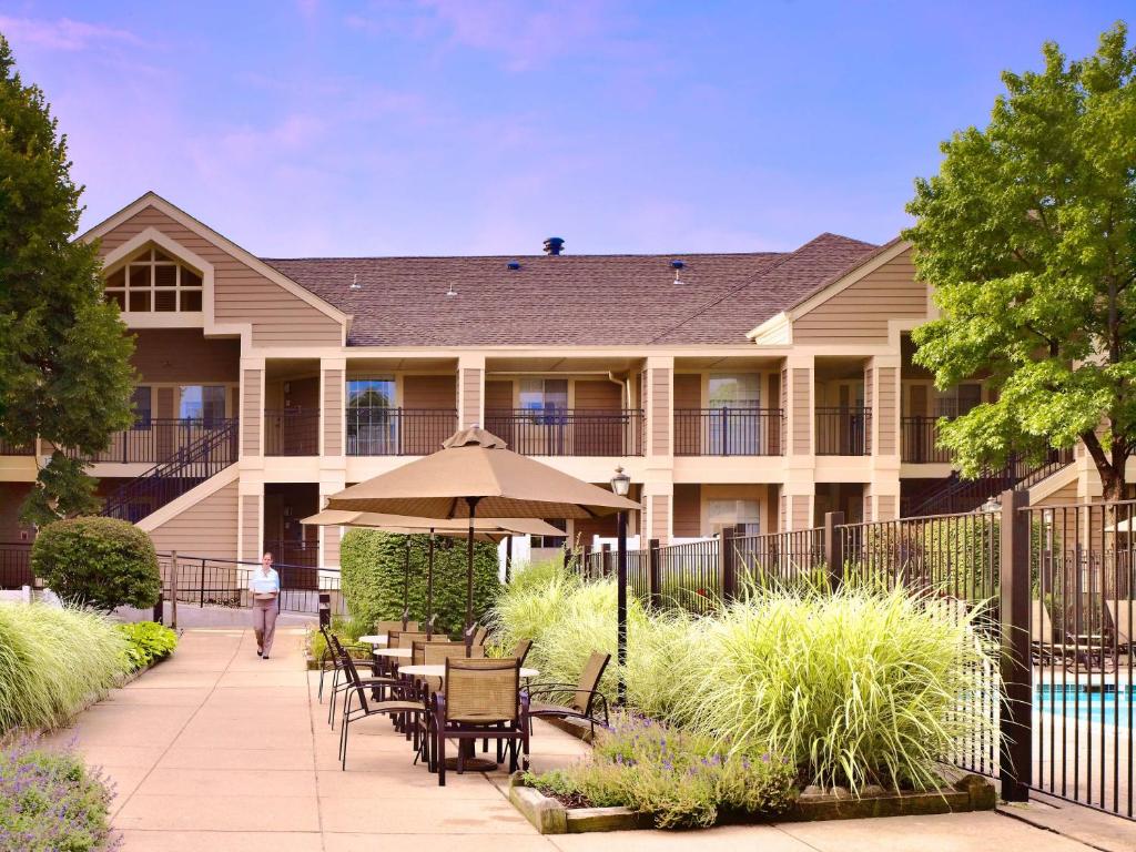 a building with a patio with tables and an umbrella at Avia Residences on Lincoln - Extended Stay in Malvern