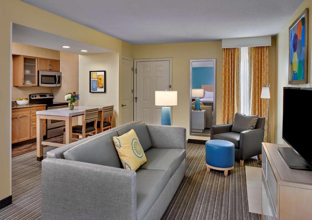 a living room with a couch and a kitchen at Avia Residences on Savoy - Extended Stay in Atlanta