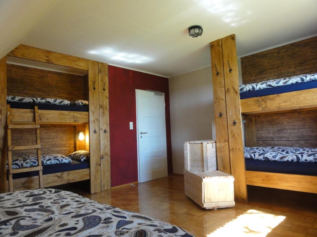 a bedroom with two bunk beds and a room with a bed at Peanuts Hostel & Meer in Surendorf