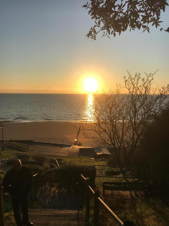 a man looking at the sunset over the ocean at Frinton Escapes in Frinton-on-Sea