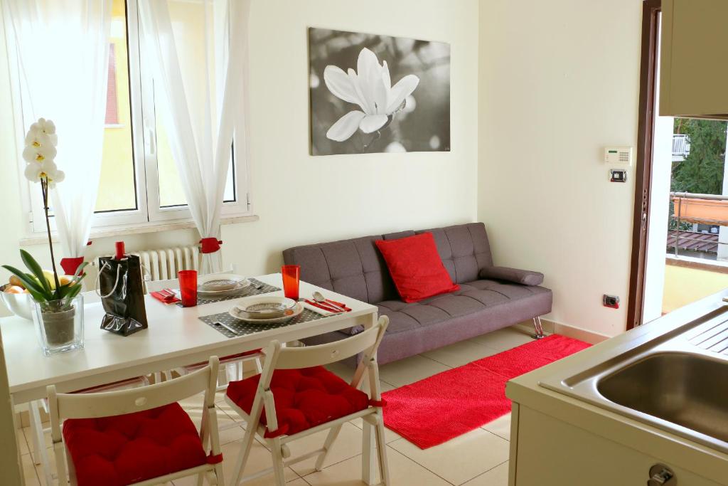 een woonkamer met een tafel en een bank bij Bilocale via Montefiore Conca in Riccione