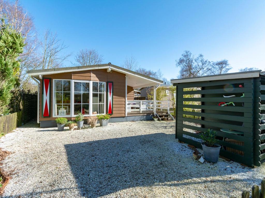 una pequeña casa con un cartel delante en Chalet aan de kust, en Sint Maartensvlotbrug