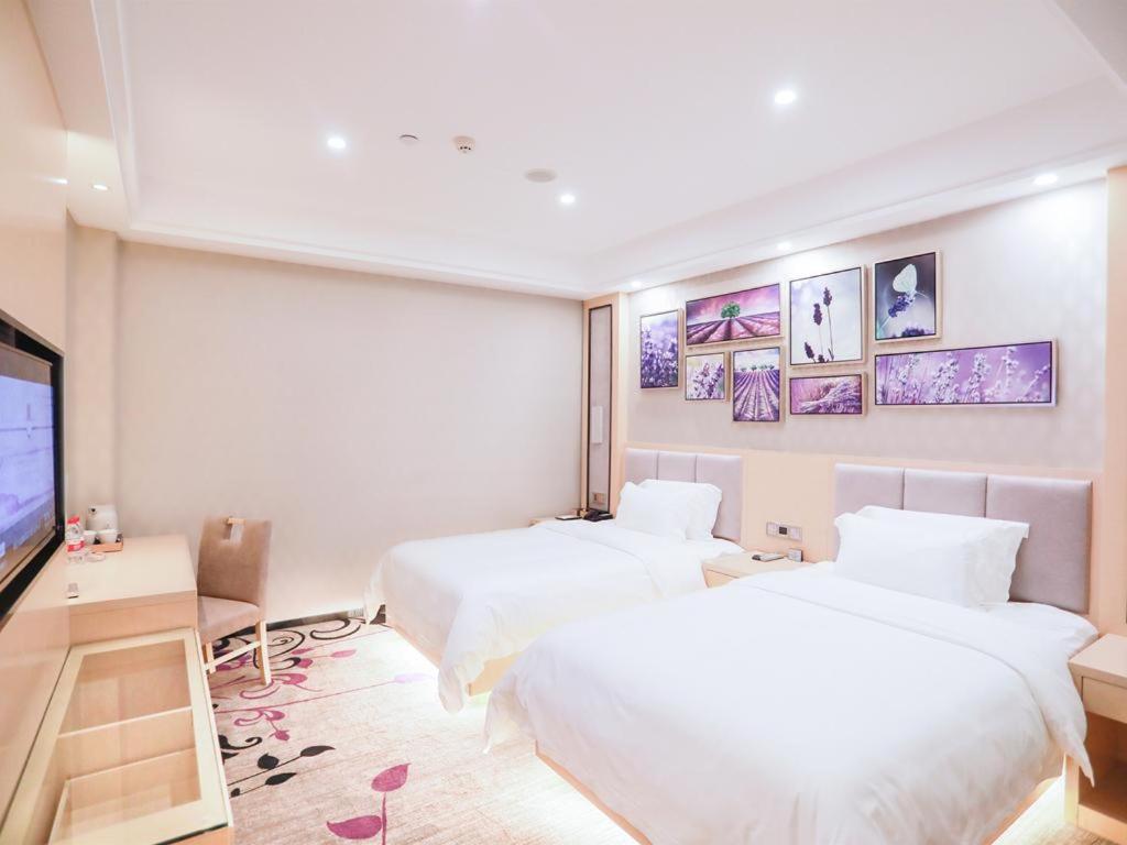ein Hotelzimmer mit zwei Betten und einem Flachbildfernseher in der Unterkunft Lavande Hotel Fangchenggang Administrative Center in Gongche