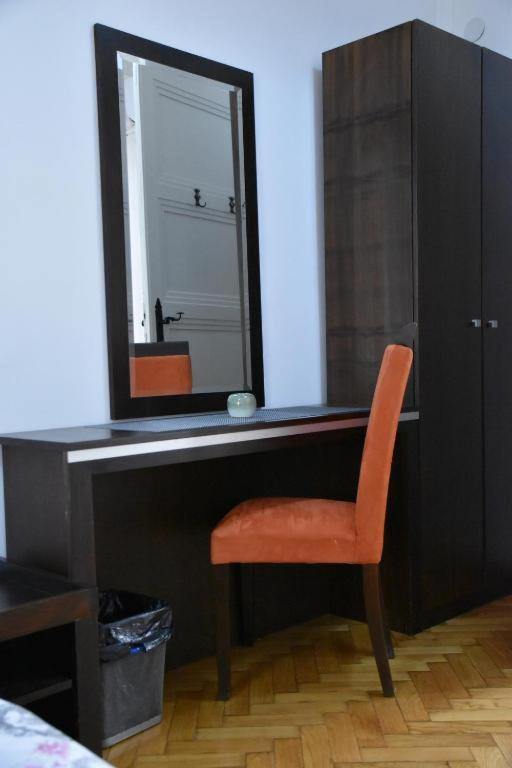 a mirror sitting on top of a desk with a chair at Exit Labirint Centar in Novi Sad