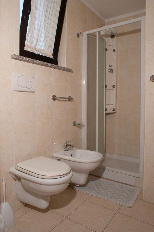 łazienka z toaletą, umywalką i prysznicem w obiekcie VILLA dei ROMANZI Residence Mare w mieście Tortoreto Lido