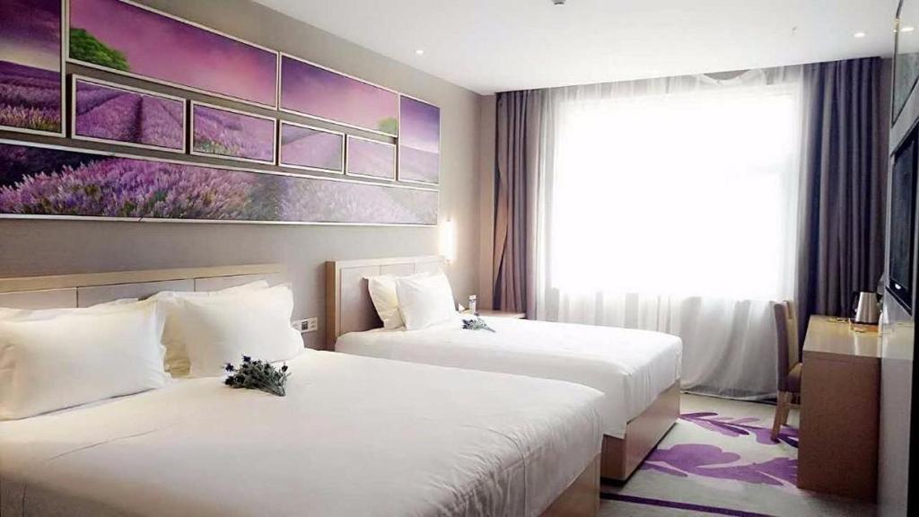 um quarto de hotel com duas camas e um quadro na parede em Lavande Hotel Yinchuan Railway Station Wanda em Yinchuan