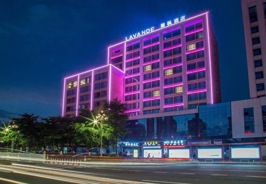 ein Gebäude mit rosa Lichtern an der Seite in der Unterkunft Lavande Hotel Qingyuan Sports Park Municipal Government in Qingyuan