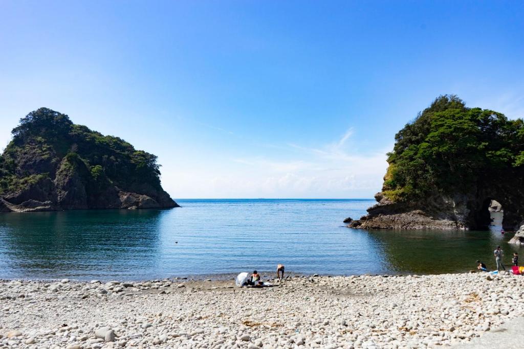 un groupe de personnes sur une plage près de l'eau dans l'établissement Dogashima Land Hohia / Vacation STAY 81112, à Tago