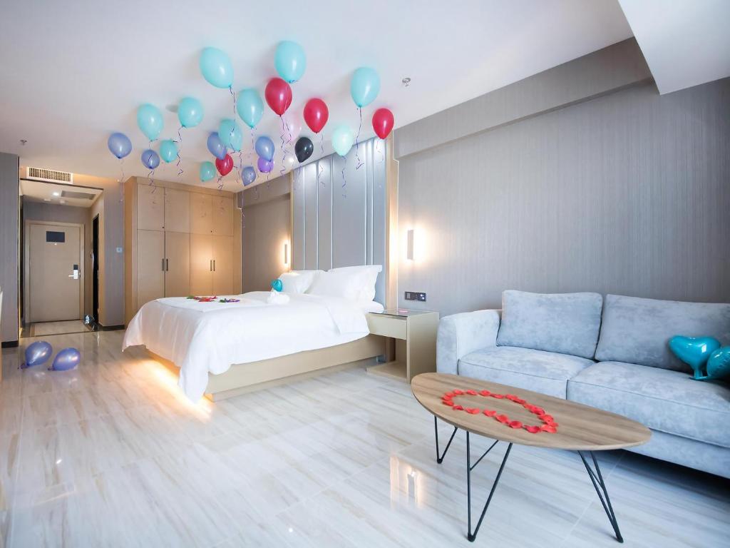 um quarto com uma cama e balões e um sofá em Lavande Hotel Urumqi High-speed Railway wanda plaza em Ürümqi
