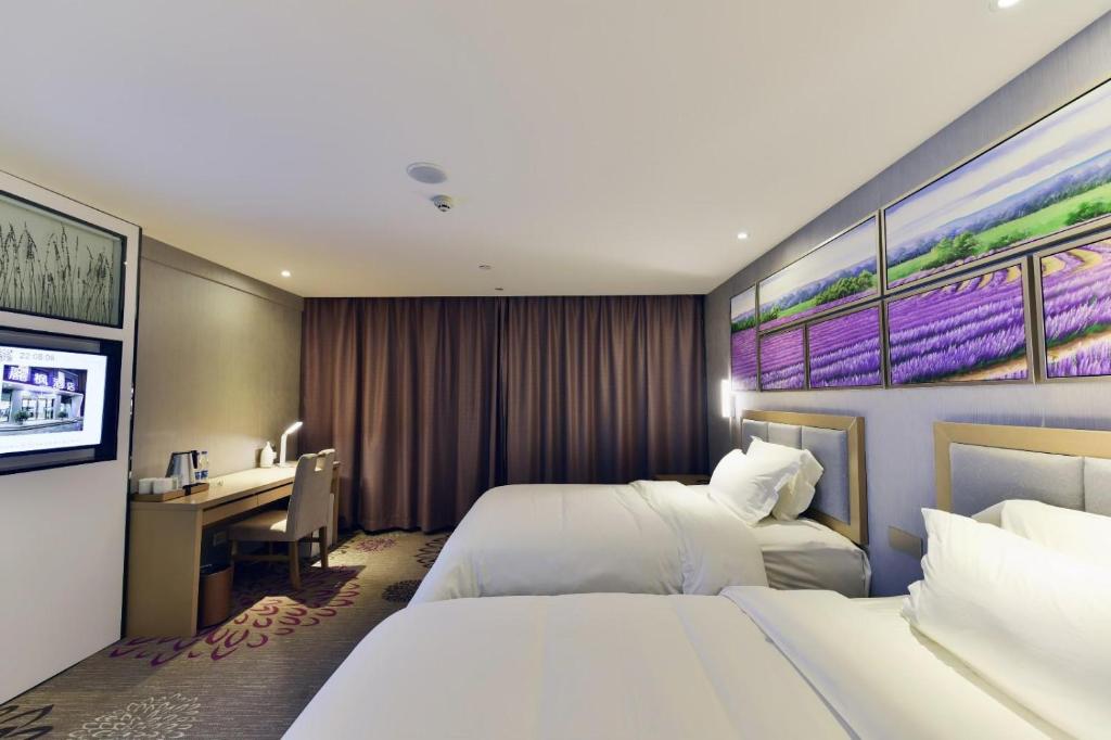 ein Hotelzimmer mit 2 Betten und einem Schreibtisch in der Unterkunft Lavande Hotel Xining Haihu New District Wanda Plaza in Xining