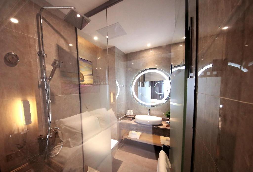 a bathroom with a shower and a toilet and a mirror at Lavande Hotel Heyuan Zijin in Heyuan