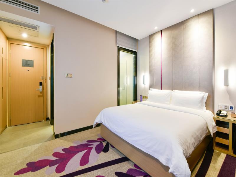 um quarto com uma grande cama branca e um corredor em Lavande Hotel Qingyuan Flying Lake em Qingyuan